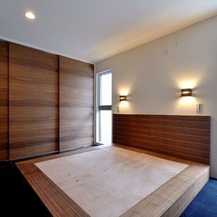 Modelo de dormitorio principal, moderno, de tamaño medio, sin chimenea, con paredes blancas, moqueta y suelo azul